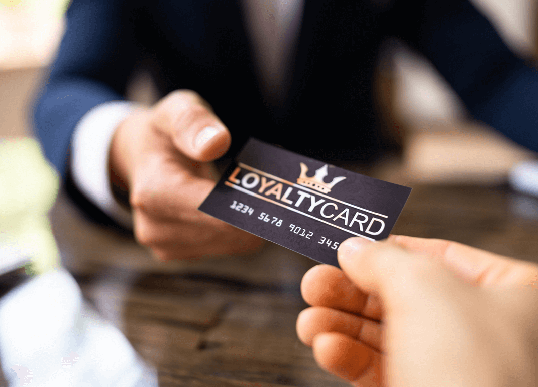 An employee giving a loyalty card to a customer.