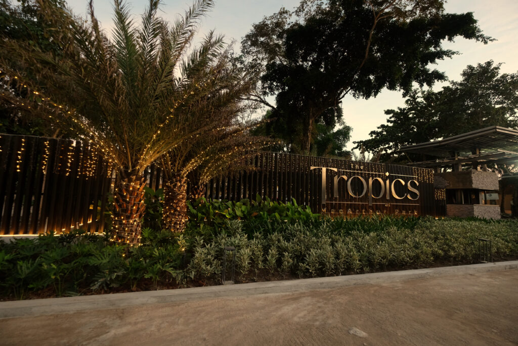 A side view of the Tropics Hotel entrance at MacArthur Park, showcasing its unique architecture and tropical landscaping.